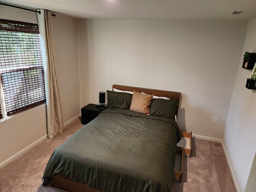 Main bedroom equipped with adjustable lamp and storage drawers under the queen-sized bed.