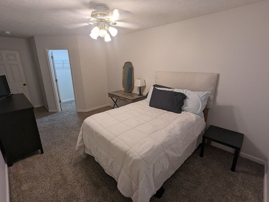 Tenant room with full bed, desk, and dresser