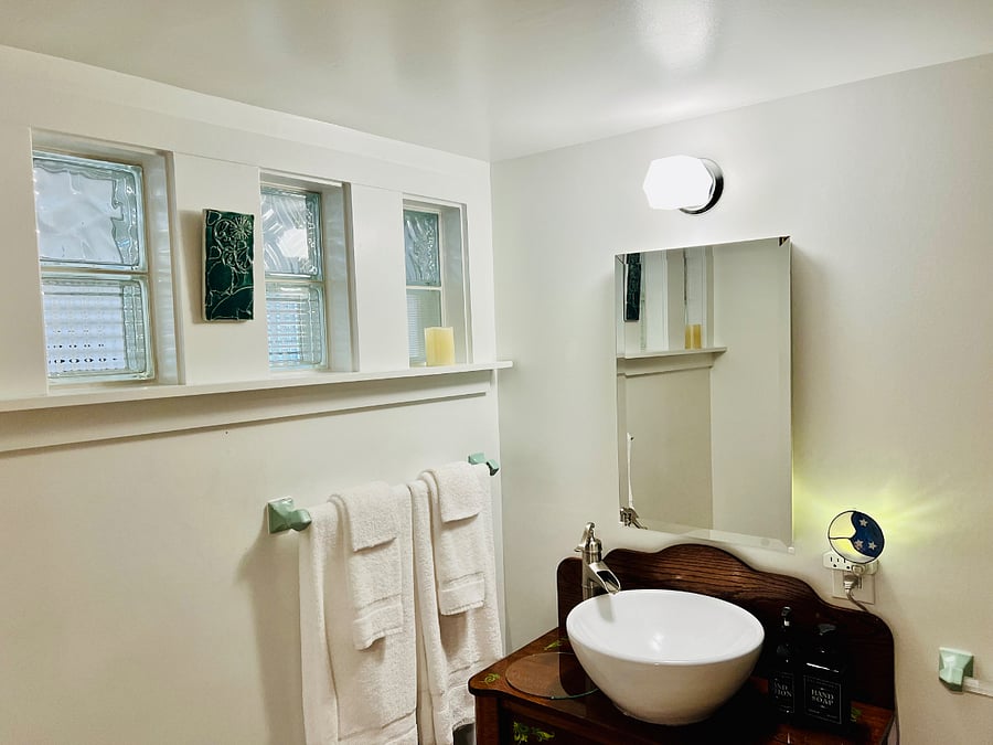 Light from bedroom shines through vintage glass bricks into the bathroom.