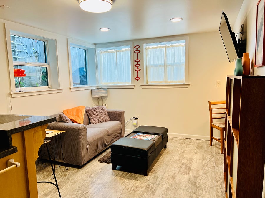 Living room with view of kitchen breakfast bar. Light on timer, feel free to unplug from timer or turn off at light. Do not unplug wifi extender.