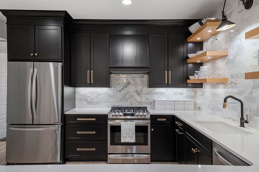 A large refrigerator with pull out freezer drawer and ice maker complement the gorgeous gas range and black cabinetry.