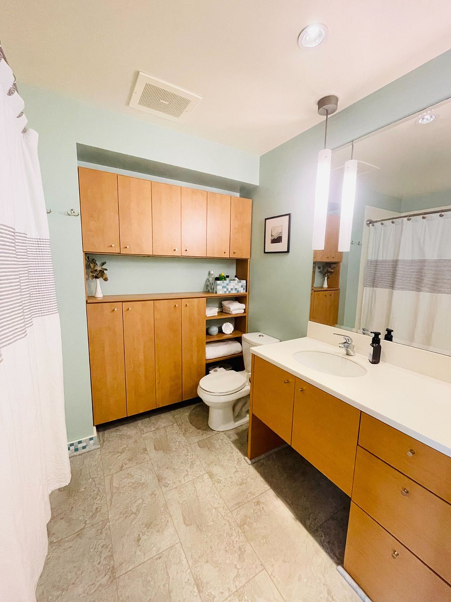 Well-lit bathroom with shower and tub