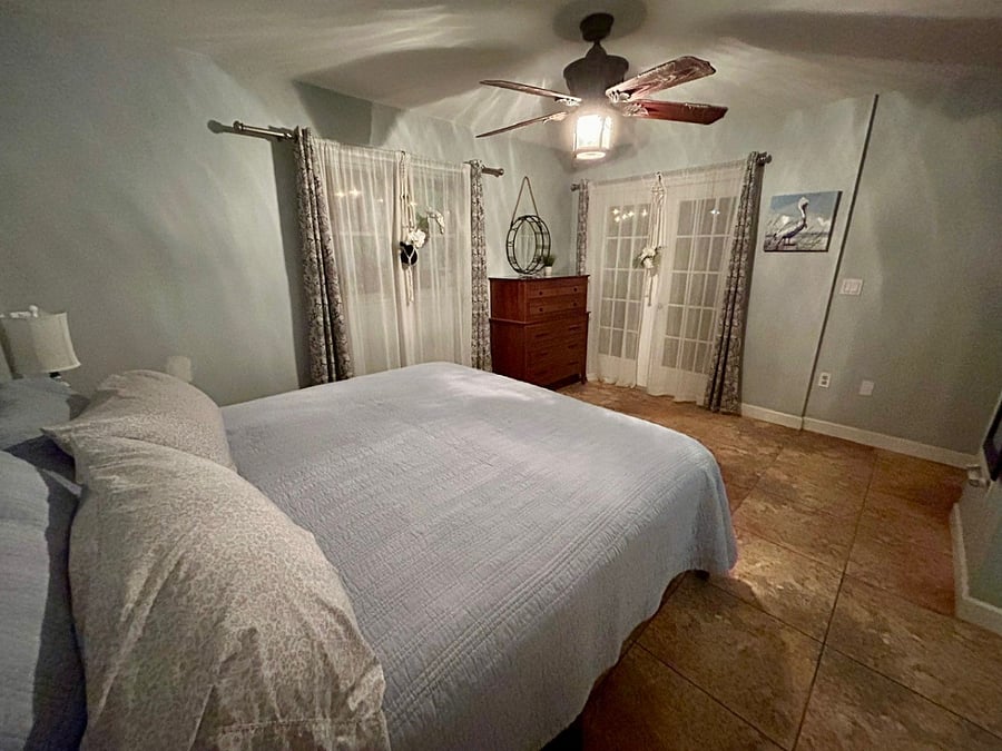 Master bedroom with double French doors opening to screened in patio.
