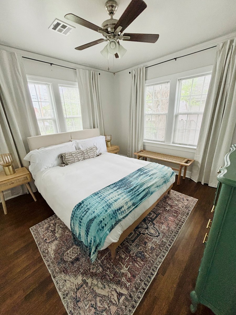 Master Bedroom with Queen sized bed, blackout curtains, tall chest of drawers, 2 nightstands and closet.