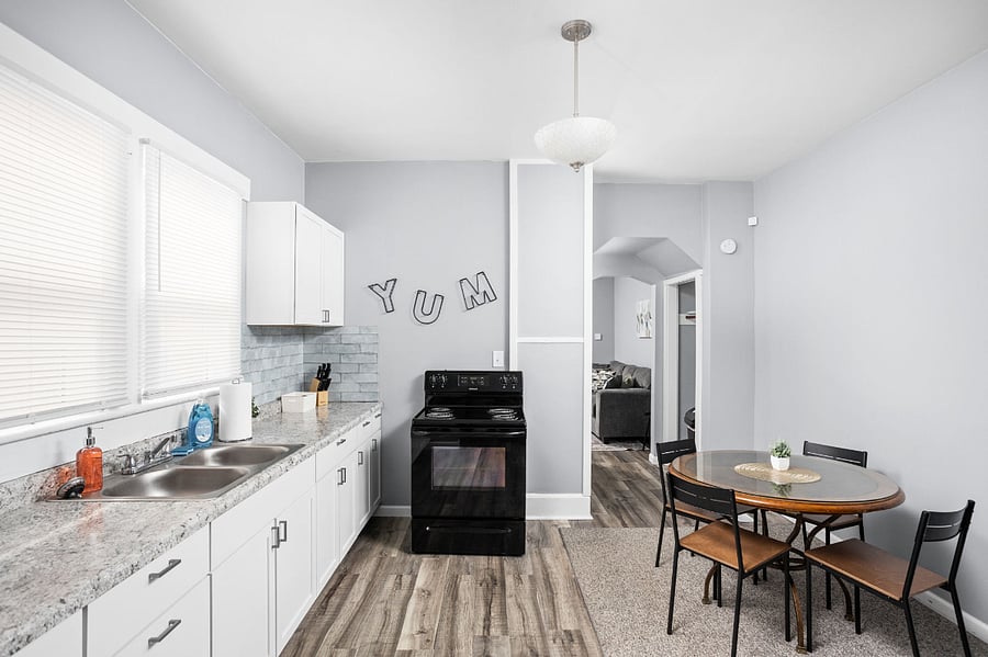 Modern kitchen with a cozy dining nook and a playful 'YUM' wall accent.