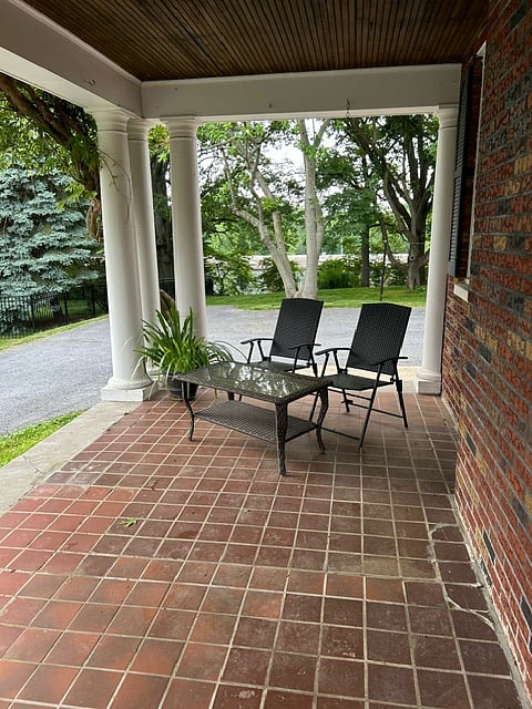 Side porch currently is set with a pair of chairs and a table for reading and relaxing. Coming soon: a BBQ and picnic table!