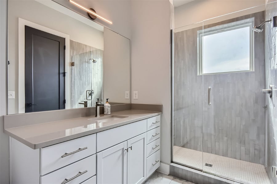 This full bathroom has an extra large shower, lots of natural light, and a laundry closet with washer and dryer in unit.