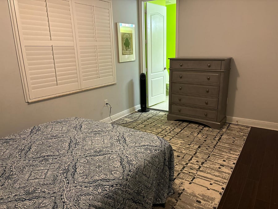 Bedroom is connected to bathroom with full tub, shower, double sink, and additional storage.