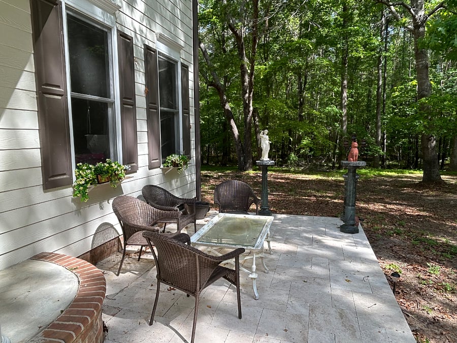 Wide travertine patio in front.