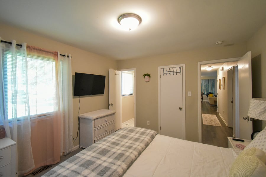 Master suite with queen bed, makeup vanity, smart tv and separate full bathroom