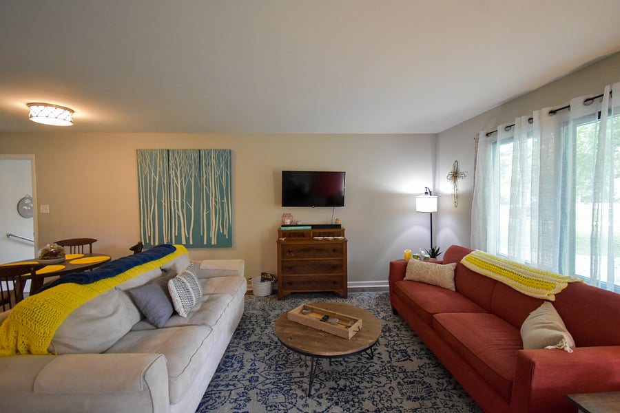 Main living room includes two couches and smart tv