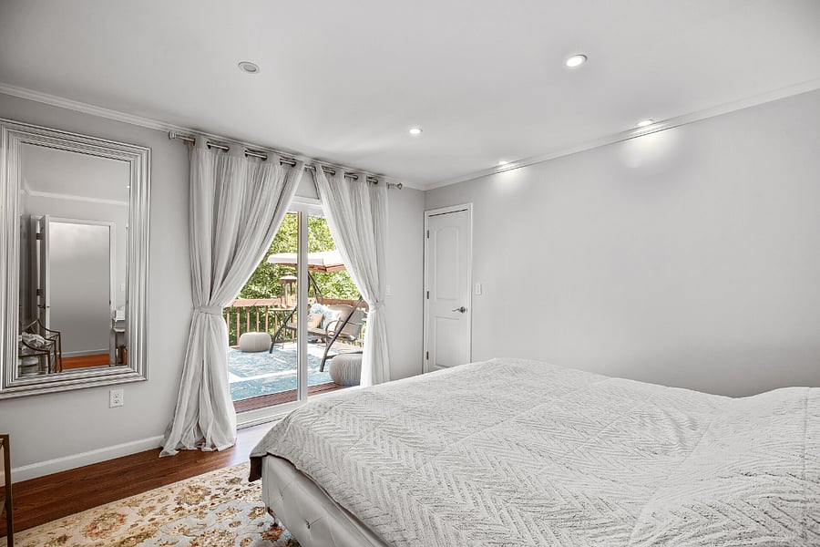 Main floor Primary Suite with king bed + bath (tub), custom walk-in closet. Access to upper deck (balcony).