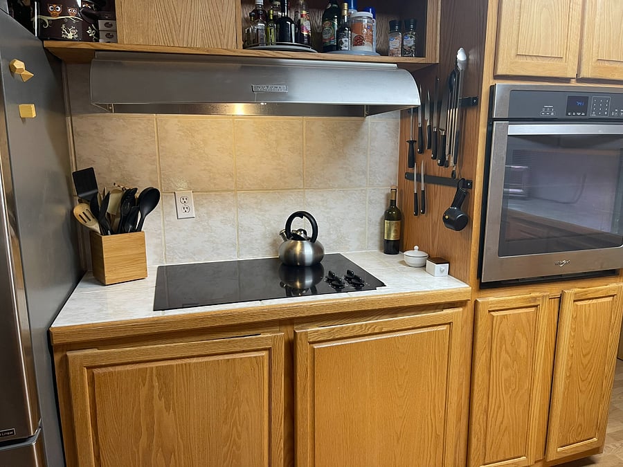 Glass top stovetop, wall oven, plenty of storage with pull out drawers full of pots and pans, equipment and storage containers.