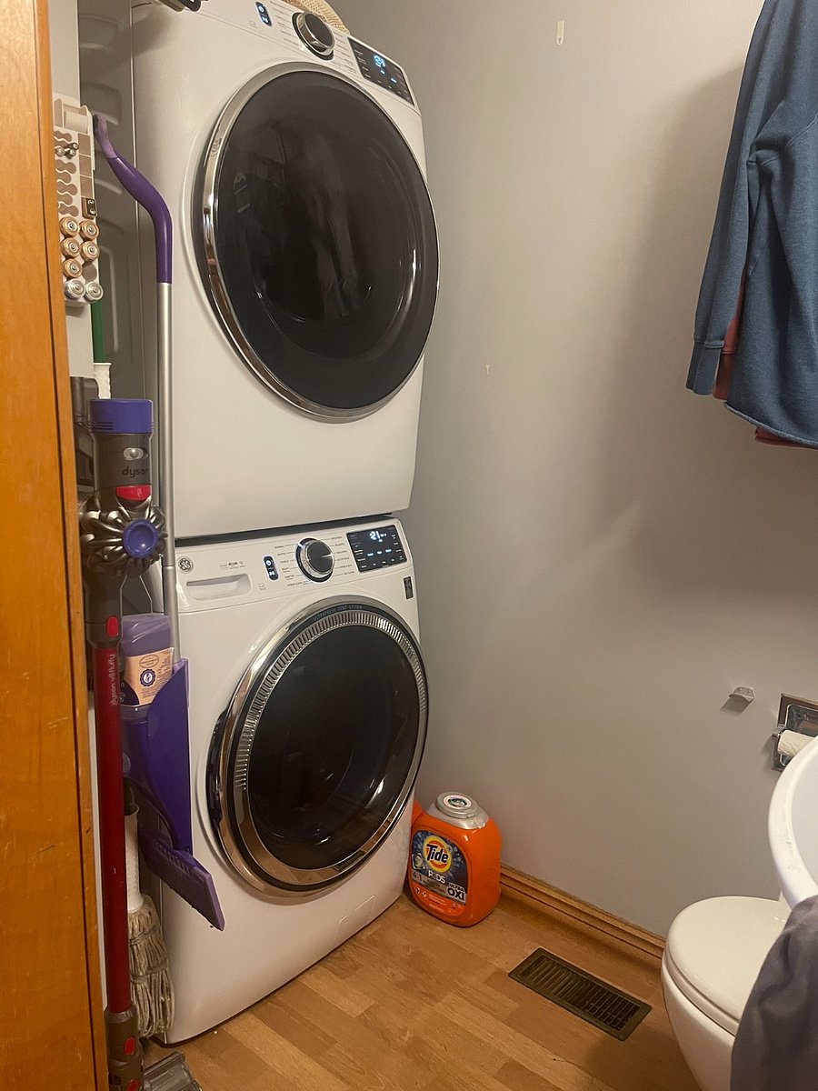 In the half bath there is a closet for storage, a large capacity stackable washer & dryer, Dyson stick vacuum, and cleaning products galore.