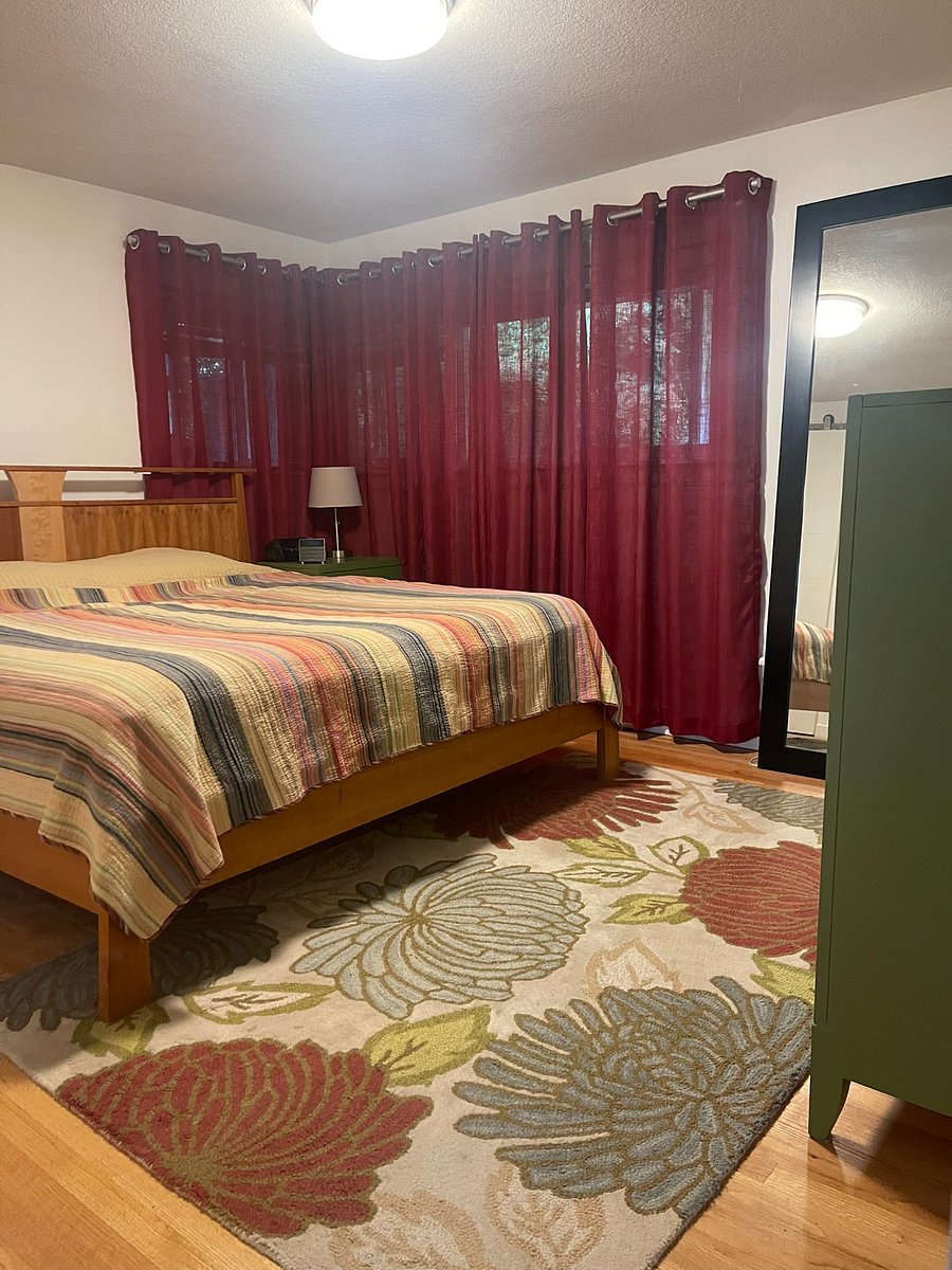 Primary bedroom with king size bed, dresser, nightstands, and large closet. Windows look out to a big Hawthorne tree. There is even an additional window air conditioner for those that like it extra cold in bedroom.