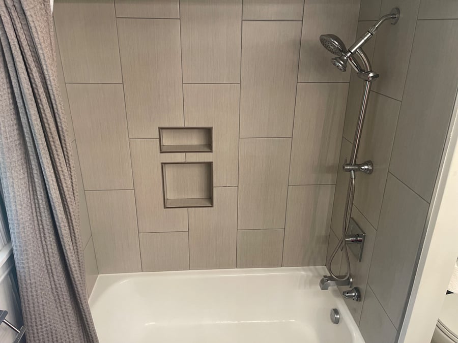 Fully tiled shower with bathtub. Shower wand can be removed, moved, and repositioned.