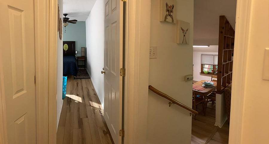 Bathroom and 2 bedrooms are located 4 steps up from the living room. Looking into main bedroom