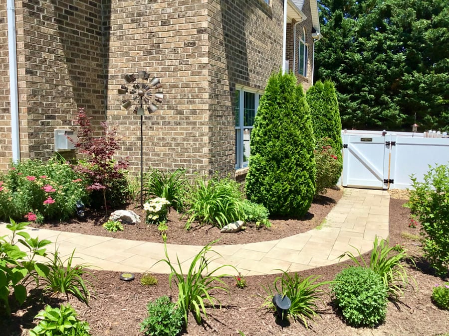 Pavered sidewalk leading into the courtyard area and apartment entrance.