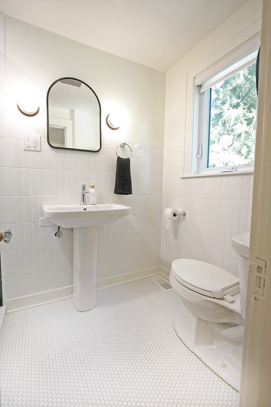 Bright and beautiful second floor bathroom features a pedestal sink and tiled walk in shower.