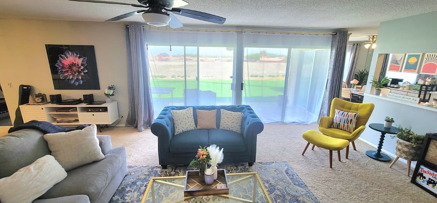 Living room double wide glass doors overlooking golf course driving range just downhill