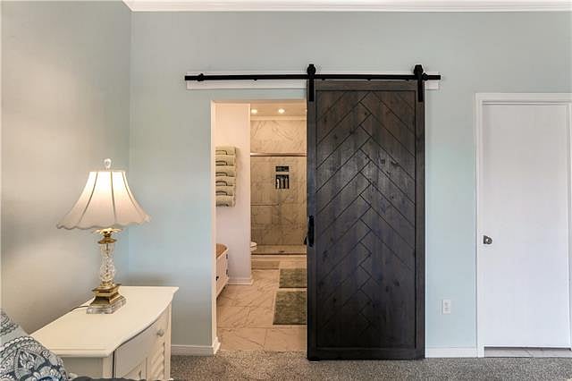 This is the primary bathroom as seen from the bedroom with the barn door open.