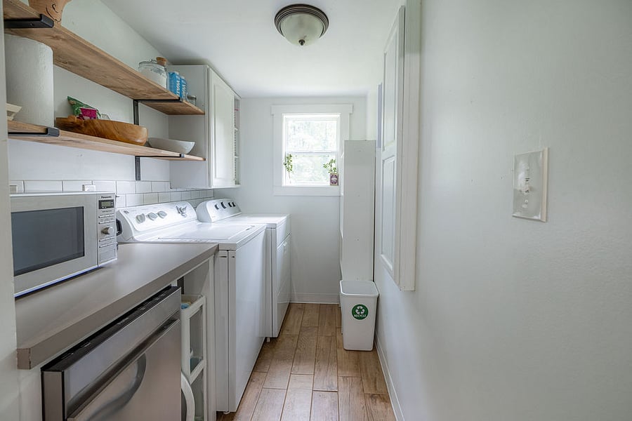 Laundry / pantry area with dishwasher, microwave, and pull-down ironing board.