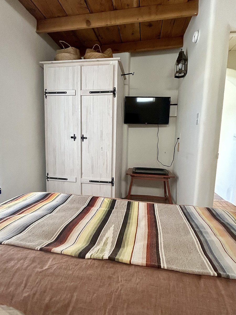View of wall-mounted 32" LG smart tv next to armoire from bed. TV loaded with Netflix and Sling streaming apps. Load yours while in residence. Fiber optic Internet service delivers great viewing.