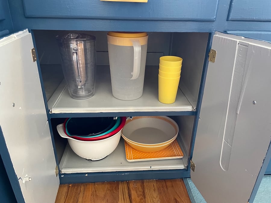 In the kitchen is also plastic pitchers, plastic cups, a mixing bowl, colander, and serving dishes.