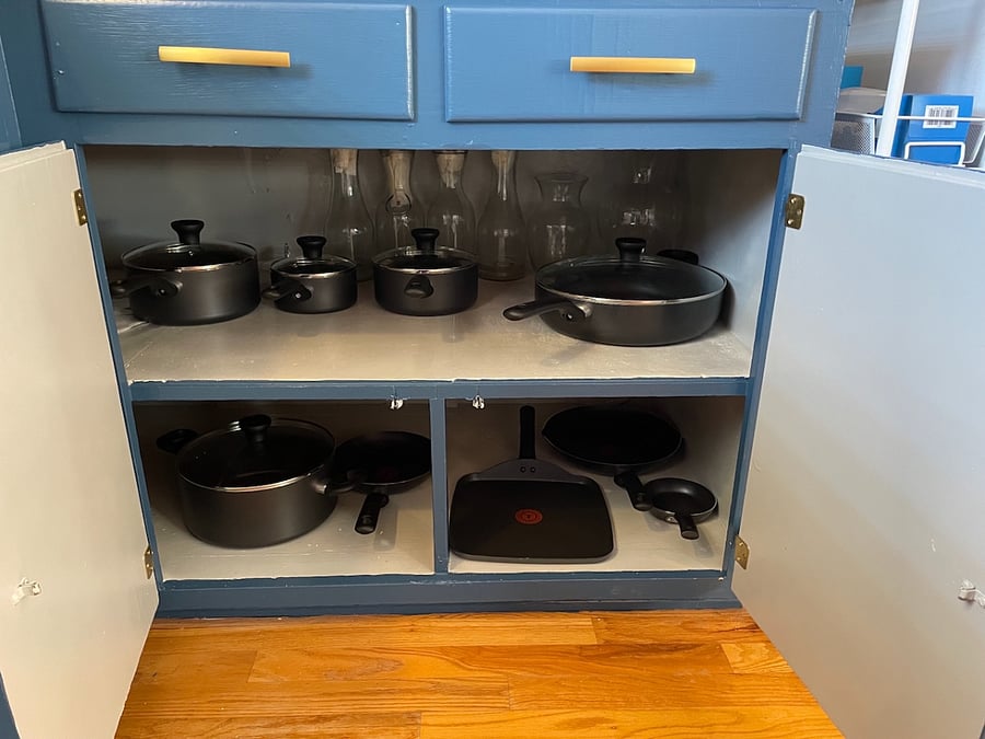Kitchen items include pot, saucepans in different sizes, and a variety of skillets.