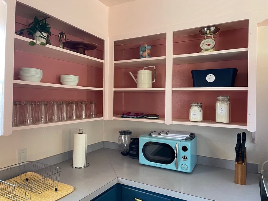 Kitchen items include: bowls, glasses, spices, cooking spray and oils , kitchen towels, trivets, containers with sugar and flour for guests to use, dish drying rack, microwave, kitchen knife set, and cutting boards.