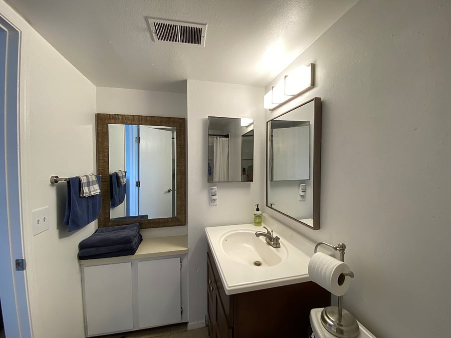 Updated bathroom with three mirrors, plenty of storage, and a full shower