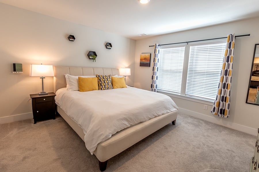 The primary has a king-sized bed and a large window with natural light.