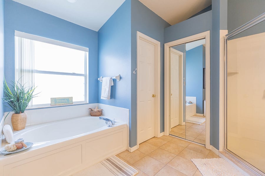 The door situated between the mirrored linen closet and garden tub is the toilet closet. There is a walk-in shower to the right. This is a very large on suite with double sinks and lots of storage space.