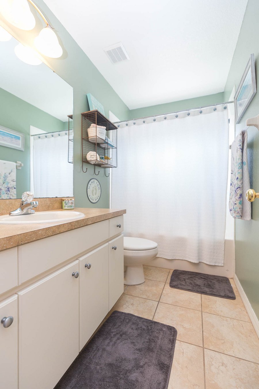 Single vanity with linen closet and shower/tub combo.