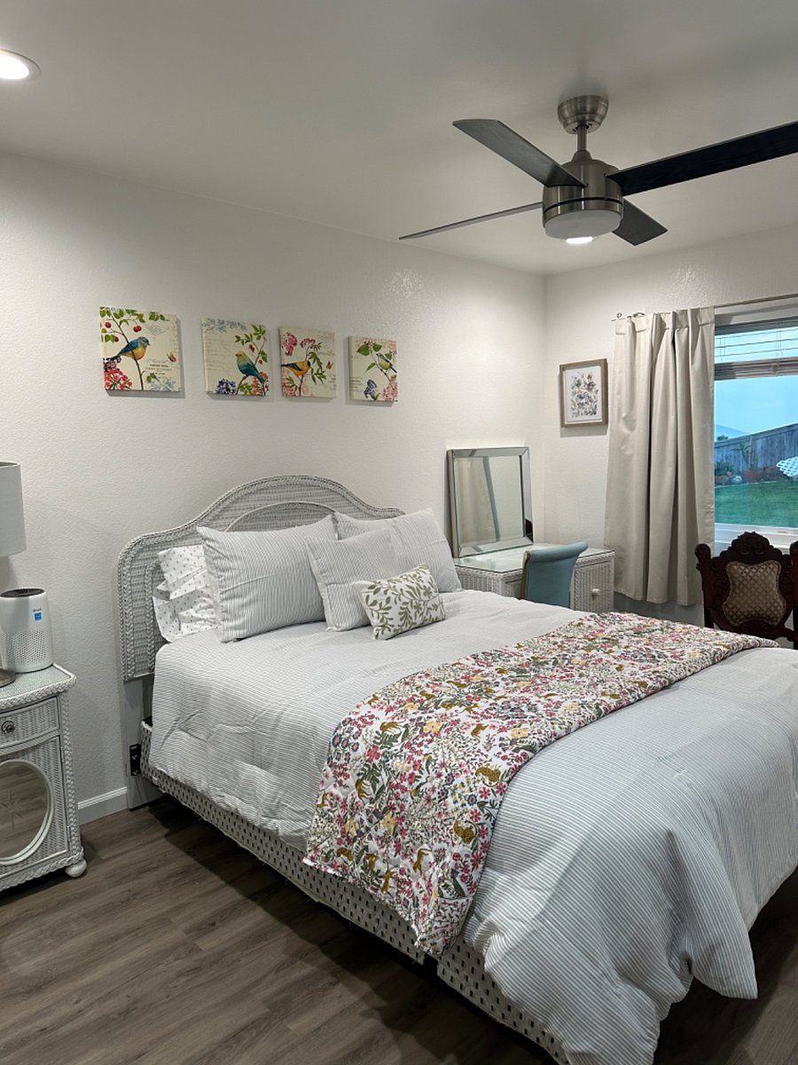 Cozy bedroom with queen bed, closet with armoire, desk, and smart TV.