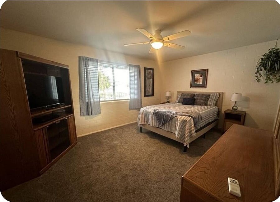 Master bedroom with smart TV and bath.