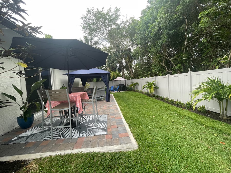 Backyard with gazebo with mosquito net and dining set