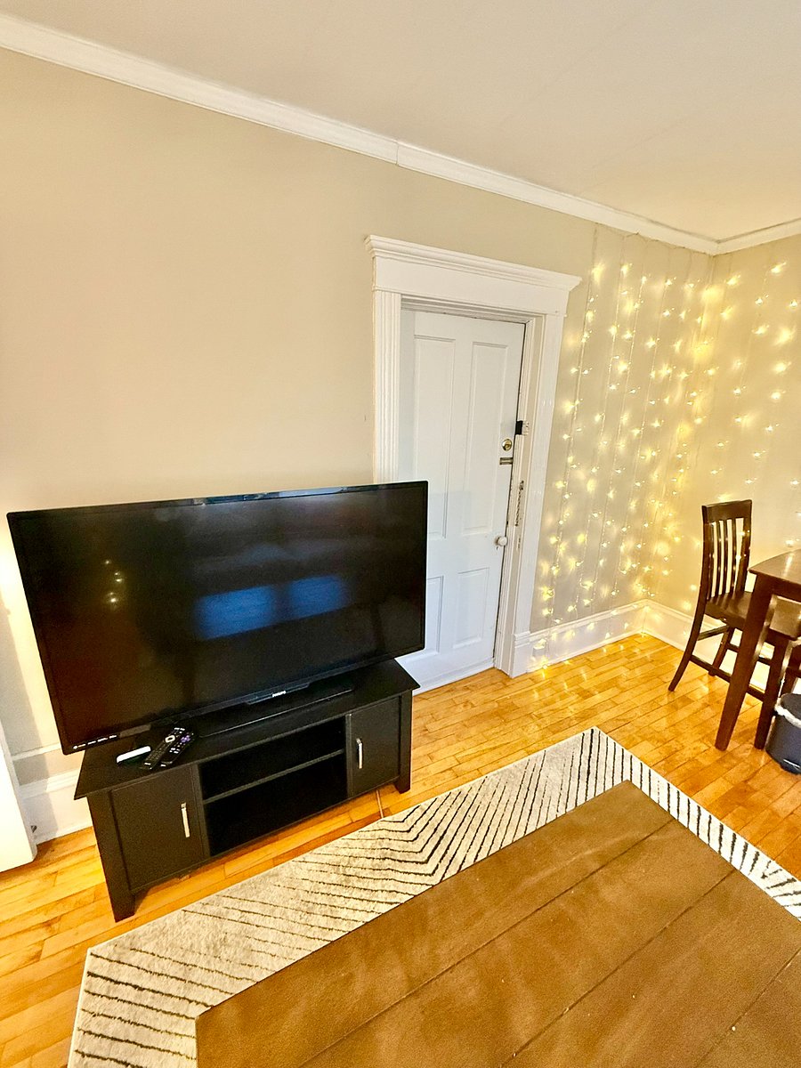 Roku smart tv. Door leads to interior stairs that can be used to exit the house at the front.