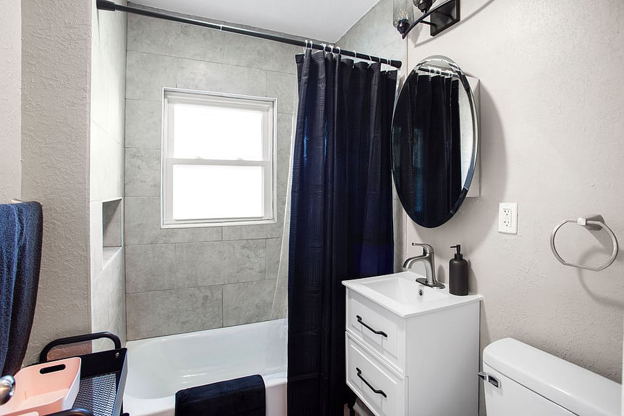 The newly updated bathroom has newly tiled shower, bright lighting, and a great shower. 