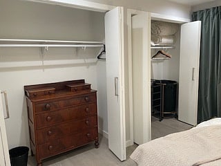 Main bedroom, with 2 closets, dresser,laundry cart and shoe rack