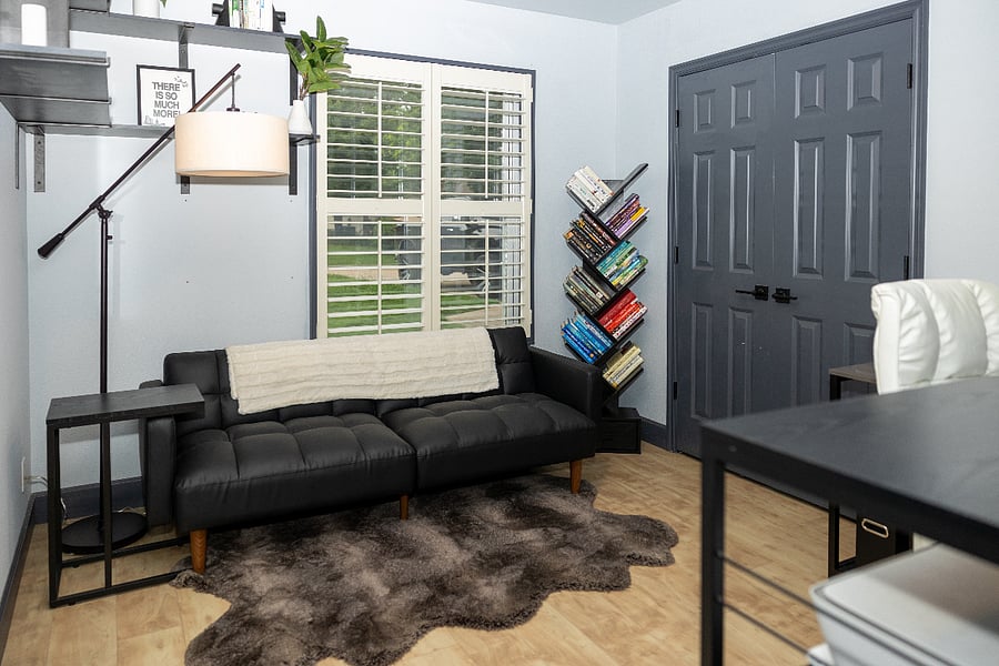 Office space with a couch, desk, and tv.