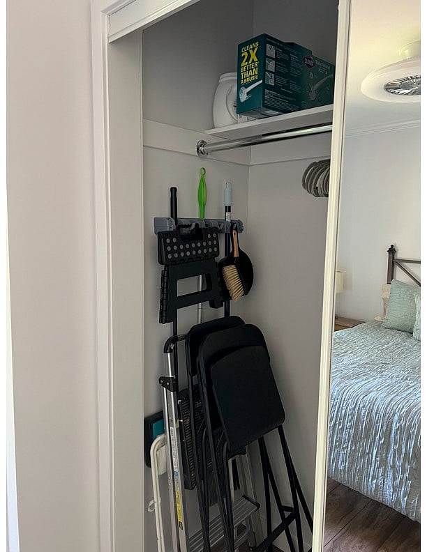 Bedroom closet w/ cleaning supplies & extra chairs