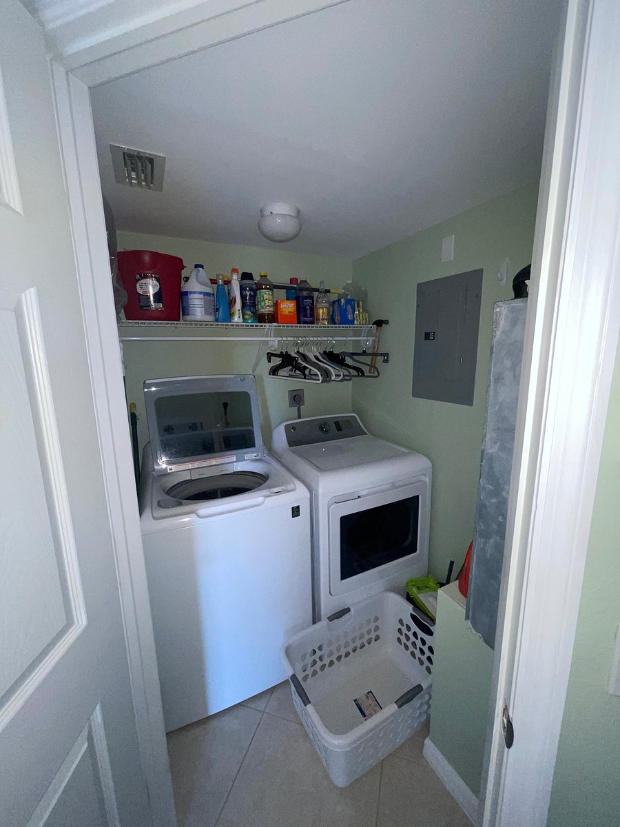 Laundry room with washer, dryer, and cleaning supplies