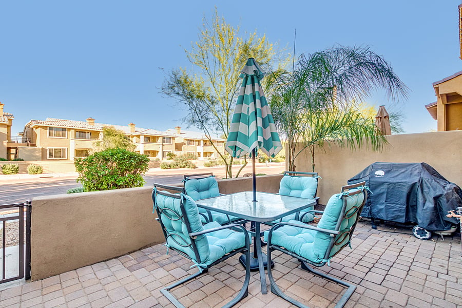 Patio with table and umbrella and weber grill.  6 chairs in total.  Epic view of McDowell Mountains! 