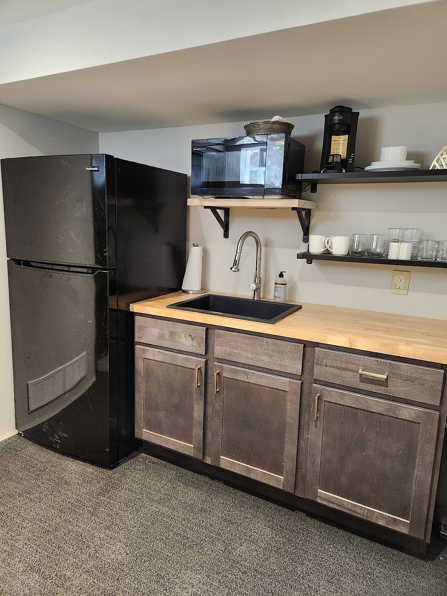 Kitchenette with microwave, toaster oven, refrigerator, and coffee maker.