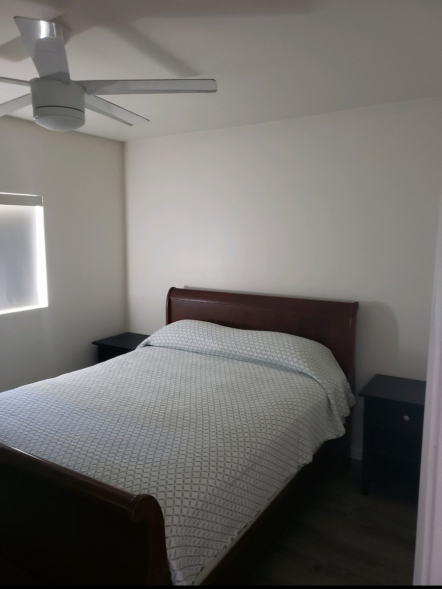Queen bed in bedroom with 2 nightstands.