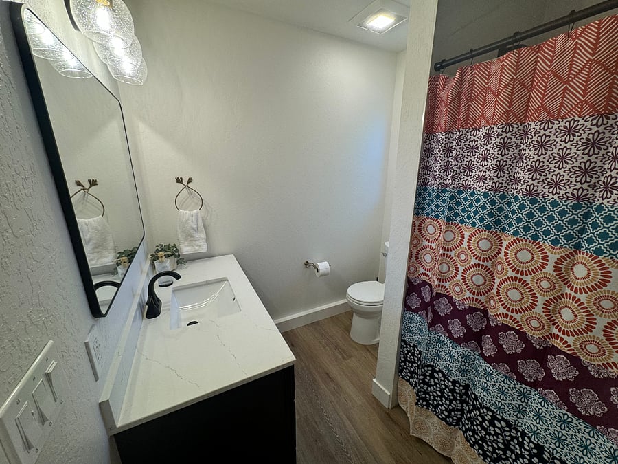 The spacious bathroom features a full-size tub and shower, and the vanity has plenty of storage.