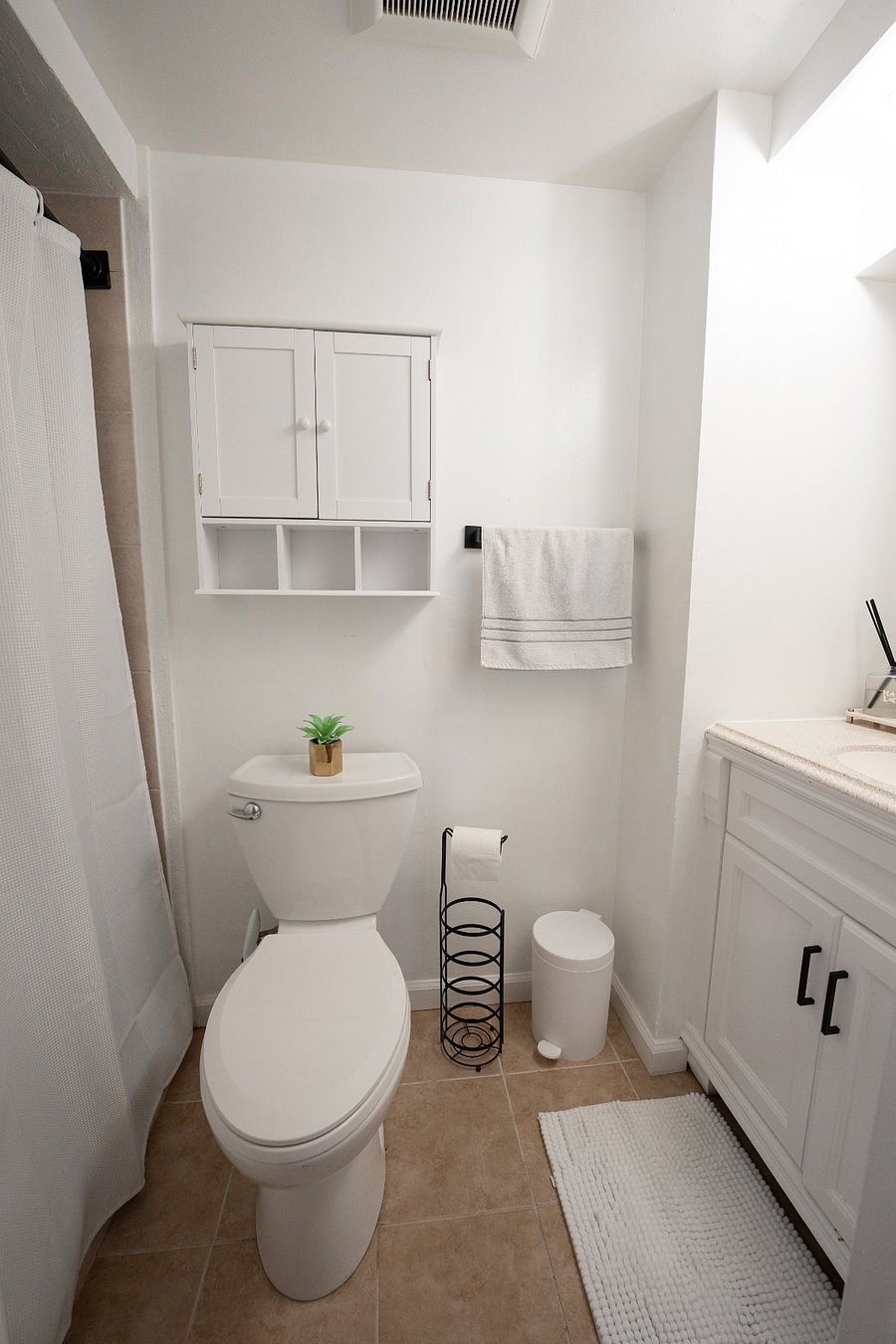 Clean bathroom with ample storage and quartz countertop. Stocked for move-in day.