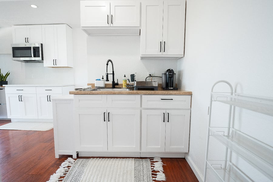 Stainless steel microwave and range hood combo, full-size fridge, and a two-burner cooktop. Simple, functional, and move-in ready.