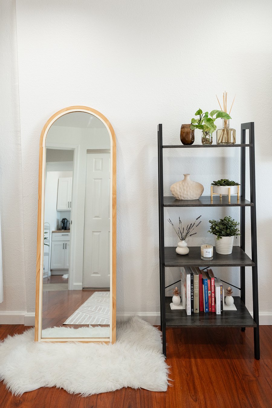 Cozy reading nook and full-length mirror in the bedroom. Styled for comfort during extended stays.
